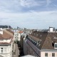 9. Bezirk Wien, Ausblick über die Dächer Wiens, blauer Himmel, leichte Schleierwolken, links und rechts jeweils ein Altbauhaus, dazwischen eine Straße