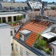 Dachterrassenwohnung im 8. Bezirk von Wien, Blick auf zwei Terrassen, möbliert und begrünt, mit Markisen, Blick über die Dächer, Dach im Vordergrund rot, mit Gaupe