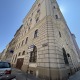 4. Bezirk von Wien, Altbau-Eckzinshaus, beige-graue Fassade, dunkelbraune Fenster, Gehsteig links und rechts,