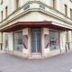 Eck-Geschäftslokal im 21. Bezirk von Wien, mittig eine vergitterte Einganstür, links und rechts davon eine Glasfront, davor ein Gehsteig